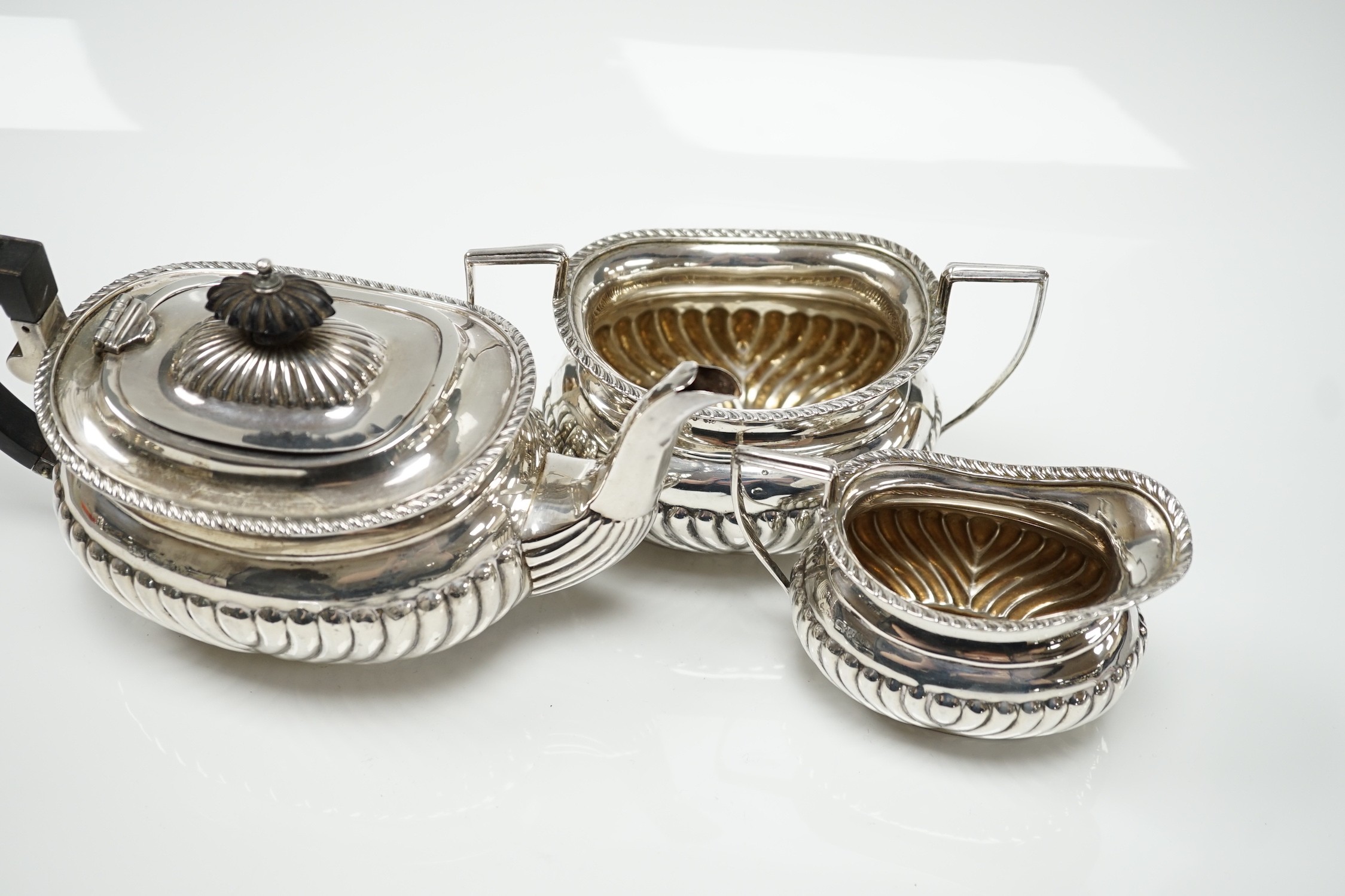 A George V demi fluted silver three piece bachelor's tea set, Jones & Crompton, Birmingham, 1913, gross weight 14.5oz.
